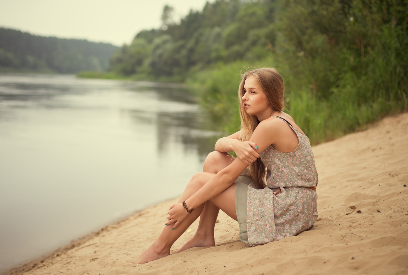 川のほとりに座る若い外国人女性