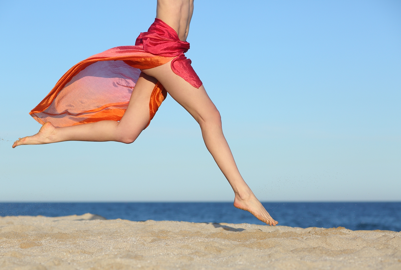 砂浜を走る女性の脚