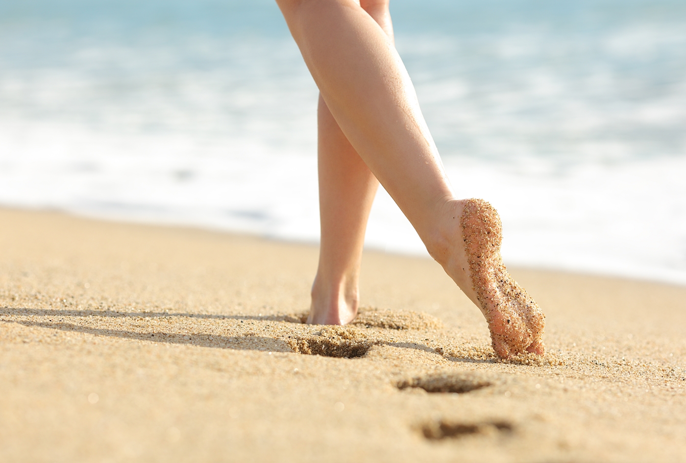 砂浜を歩く女性の脚
